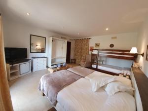 a bedroom with a large bed and a flat screen tv at Agroturisme Na Martina in Portopetro