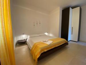 ポルト・ピノにあるSabrina Apartmentsのベッドルーム1室(黄色い毛布付きのベッド1台付)
