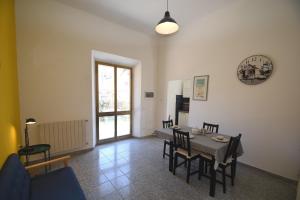 a living room with a table and chairs at PRIMAVERA TRILO - Zona mare con spazio esterno, clima e posto auto in Marina di Campo