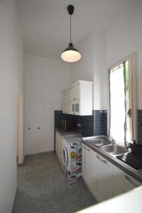 a kitchen with white cabinets and a sink and a window at PRIMAVERA TRILO - Zona mare con spazio esterno, clima e posto auto in Marina di Campo +16 photos