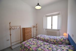 a bedroom with two beds and a window at PRIMAVERA TRILO - Zona mare con spazio esterno, clima e posto auto in Marina di Campo