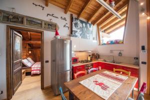 eine Küche mit einem Holztisch und einem Kühlschrank in der Unterkunft Baita di charme con vista meravigliosa in Verrayes