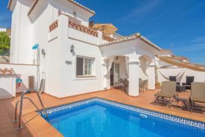 a villa with a swimming pool in front of a house at Villa privada con increíbles vistas al mar in Torrox Costa