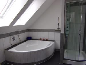 a bathroom with a large tub and a shower at Stadthaus Kaufbeuren in Kaufbeuren +51 photos