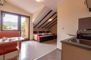 a room with a bed and a kitchen with a sink at Denicia Apartments in Ohrid
