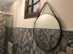 a mirror hanging on a wall in a bathroom at Preciosa casa baja con aire acondicionado in Sanlúcar de Barrameda +22 photos