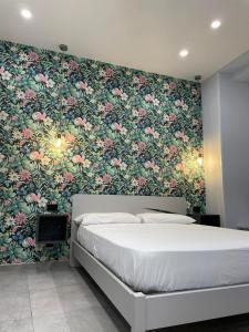 1 dormitorio con 1 cama y papel pintado con motivos florales en Terrazza Aragon Room and SPA, en Nápoles