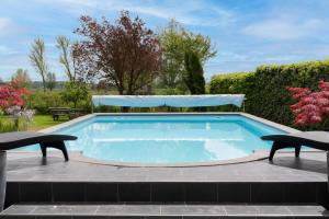 a swimming pool with two chairs and a table at Bed & Breakfast De Heughte in Oosterwolde