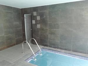 a swimming pool in a bathroom with a tile wall at Le gite du chtihameau avec piscine intérieure privative, selon date in La Bassée