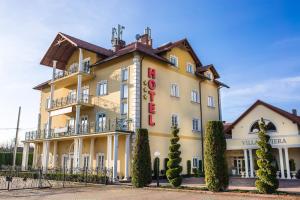 um grande edifício amarelo com um sinal nele em Hotel Villa Riviera em Rzeszów