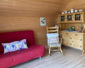 een woonkamer met een rode bank en een stoel bij Ferienwohnung Lechglück in Pflach