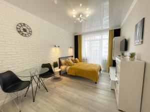a bedroom with a bed and a table and chairs at Apartment Studio New York 45 in Irpin