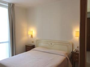 een slaapkamer met een wit bed en twee nachtkastjes bij Genovese Villa Elena Residence in Varazze