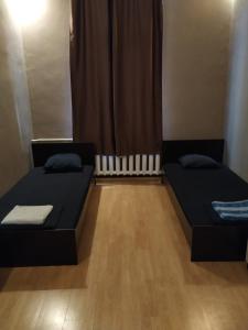 a room with two beds and a window with curtains at Best private rooms In the center in Sofia