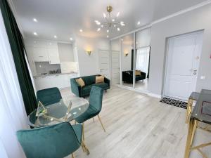a living room with a glass table and chairs at Luxury Emerald Apartments in Irpin +23 photos