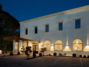 um edifício branco com uma fachada iluminada à noite em Hotel Niccolo' V - Terme dei Papi em Viterbo