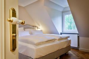 a bedroom with a white bed with a window at Mimosa House in Westerland