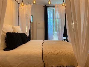 1 dormitorio con cama blanca y cortinas blancas en My Pad Provence 7 en Aviñón