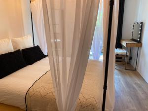 łóżko z białymi zasłonami w pokoju w obiekcie My Pad Provence 7 w Awinionie