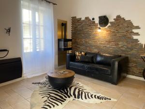 a living room with a black leather couch and a zebra rug at My Pad Provence 7 in Avignon