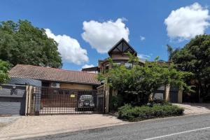 a brick house with a gate on a street at Luxury Villa Nelspruit in Nelspruit