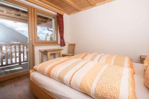 ein Schlafzimmer mit einem Bett und einem großen Fenster in der Unterkunft Eguia in Wolkenstein in Gröden