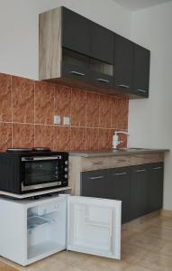 a kitchen with black cabinets and a microwave at Apartman Kata in Vrnjačka Banja