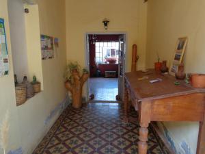 a room with a wooden table and a hallway at Hostal La Antigua in Humahuaca