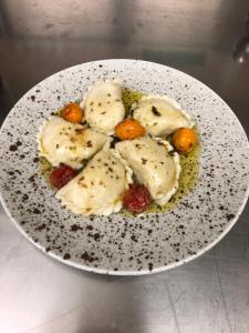 a white plate with dumplings on a table at Ferienhotel Sunshine in Berg im Drautal
