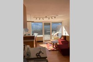 - un salon avec un canapé rouge et une vue sur la cuisine dans l'établissement Wohnung 35m2 mit Traum Panorama und 30m2 Terrasse, à Bad Aussee