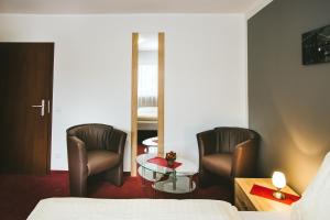 une chambre d'hôtel avec deux chaises et une table dans l'établissement Schultes Landhaus, à Delbrück