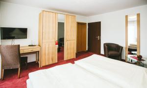 a hotel room with a bed and a desk with a computer at Schultes Landhaus in Delbrück