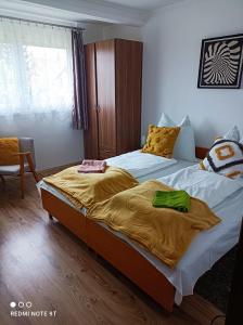 "ハルカーニャ"にあるÁgnes Apartmanokのベッドルーム1室(黄色いシーツを使用したベッド2台付)