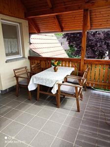 - une table et deux chaises sur une terrasse couverte dans l'établissement Ágnes Apartmanok, à Harkány