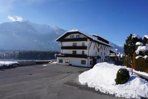 un edificio con un montón de nieve delante de él en Ferienhotel Sunshine, en Berg im Drautal