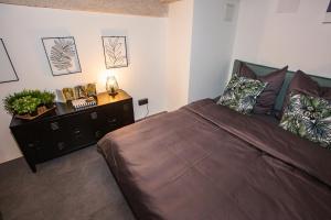 a bedroom with a large bed and a dresser at UrbanJungle - Your trendy loft in central Budapest in Budapest