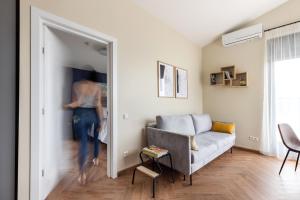 una mujer está entrando en una sala de estar en #stayhere - Seaside Story Modern 1BDR Apartment with Terrace, en Palanga