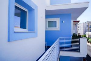 a blue and white house with a balcony at Mareluce B&B in Porto Cesareo