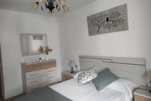 Un dormitorio con una cama, una cómoda y un espejo. en La Luz de Vejer, en Vejer de la Frontera
