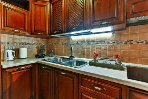 a kitchen with wooden cabinets and a sink at apartman 367 in Kotor +9 photos