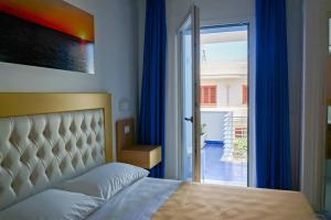 a bedroom with a bed and a door to a balcony at Mareluce B&B in Porto Cesareo