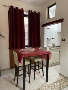 a dining room with a red table and chairs at Il vicoletto in Brindisi