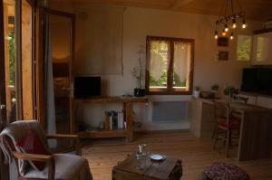 a living room with a table and a window at Le P'tit Chalet de la Fressine in Alex