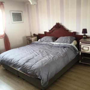 a bedroom with a large bed with a wooden headboard at villa Natacha in Villeparisis