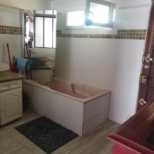a large bath tub in a bathroom with a window at villa Natacha in Villeparisis