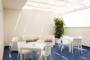 a dining room with white tables and white chairs at B&B Mareluce in Porto Cesareo