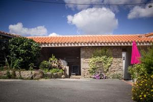 a building with a pink umbrella in front of it at Domaine des fées in La Gaubretière