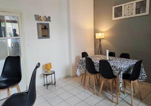 a dining room with a table and black chairs at CAP NATURE - T4 et T3 en Périgord vert - horaires adaptables- Idéal PROS et GROUPES in Champniers-et-Reillac