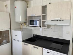 a kitchen with a white refrigerator and a microwave at Résidence Fort de l'Eve - T2 à 380m plage M Hulot et commerces - St Marc sur Mer idéal famille proche La Baule P0rnichet avec parking privé in Saint-Nazaire +30 photos