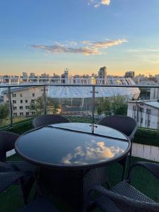 a table and chairs on a balcony with a view of a city at Royal Olympic Hotel in Kyiv
